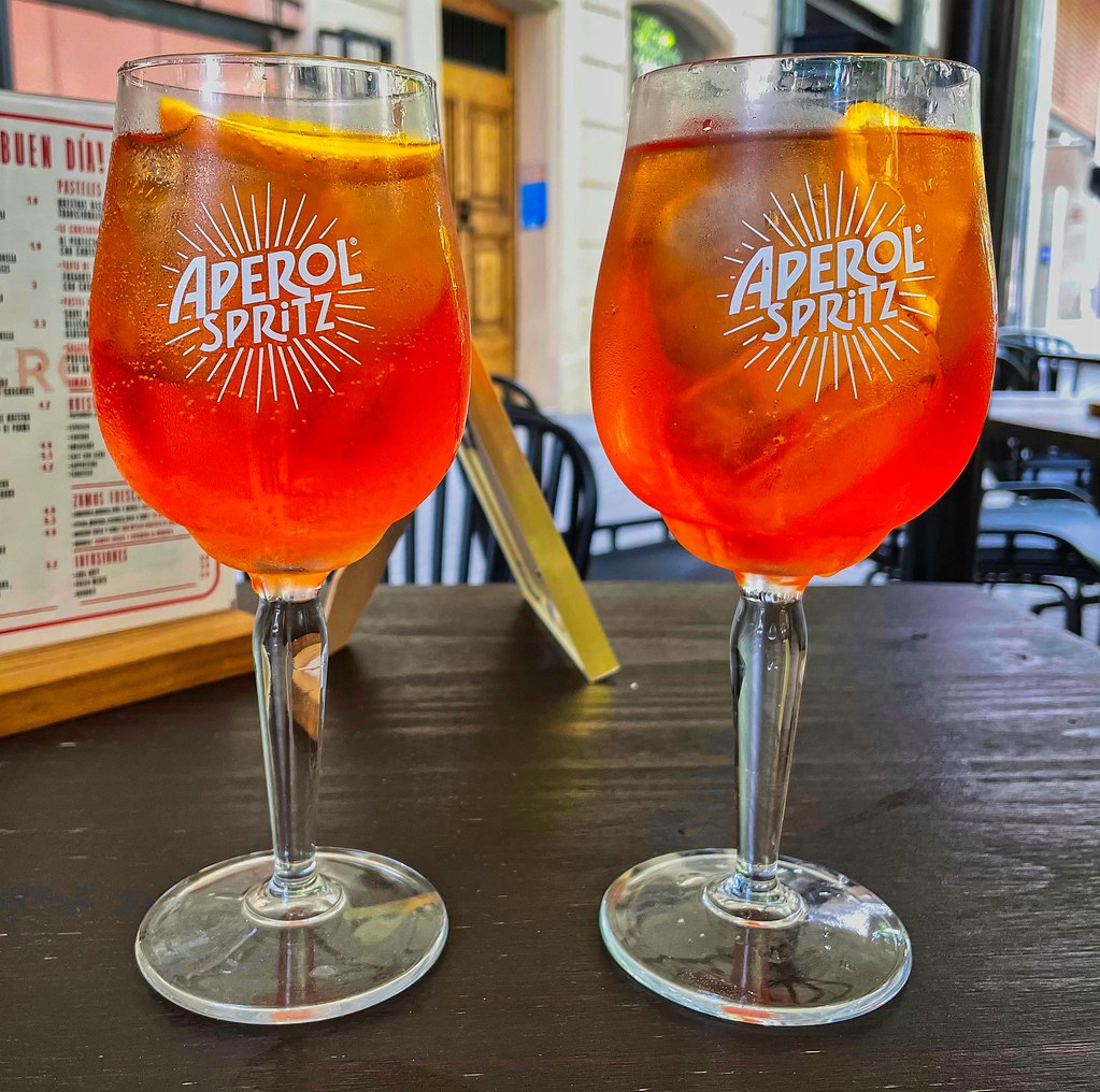 Two Aperol spritzes on a cafe terrace