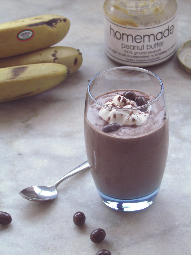 A creamy banana drink with bananas behind