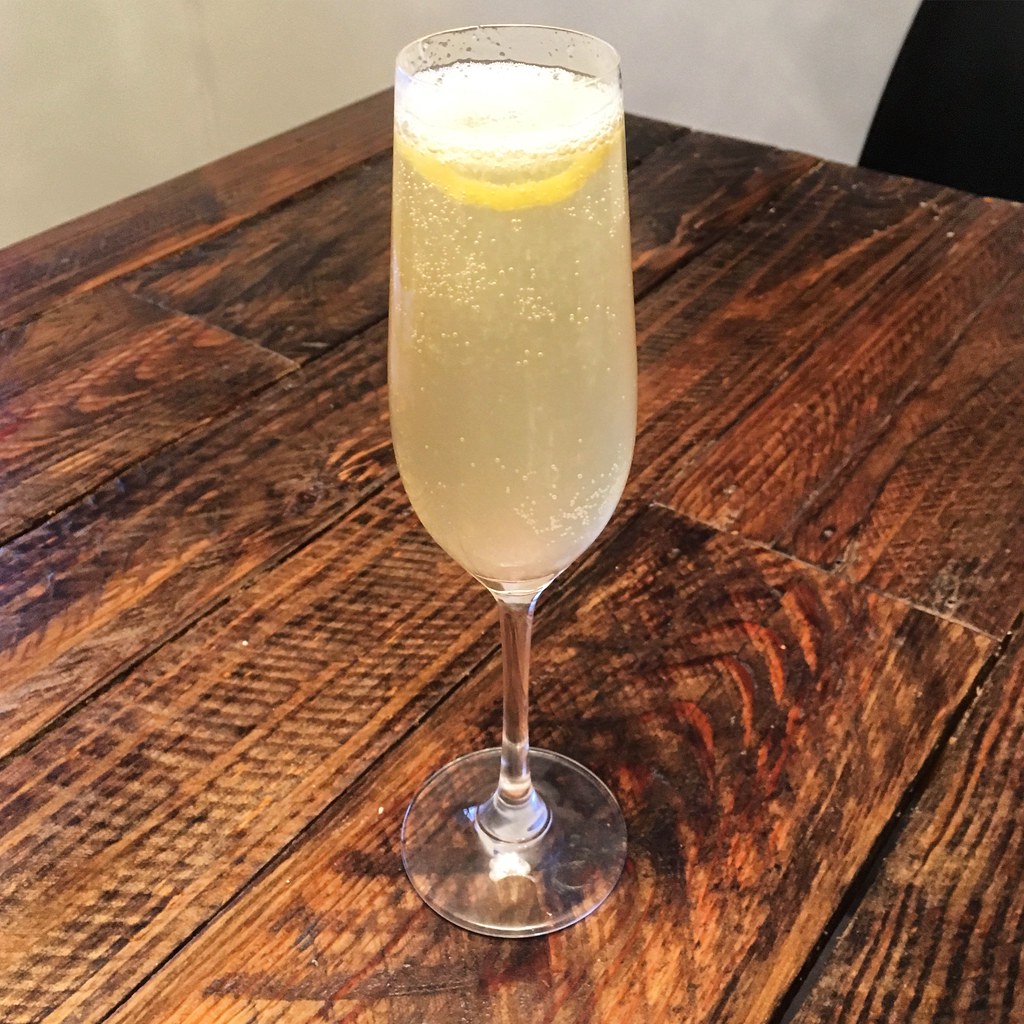 A pale sparkling spritz with a lemon wheel