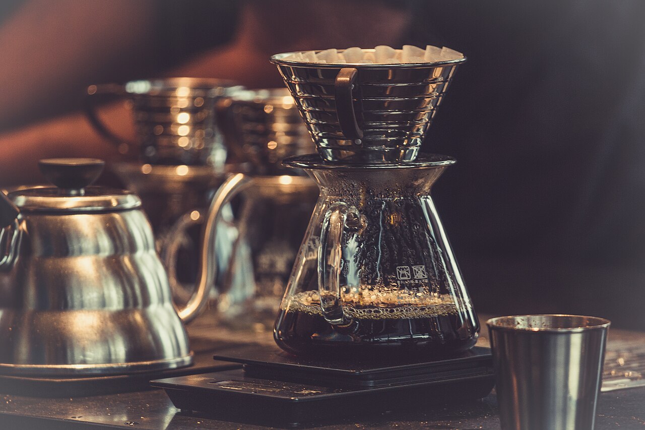 A pour-over brewing on a scale with a gooseneck kettle