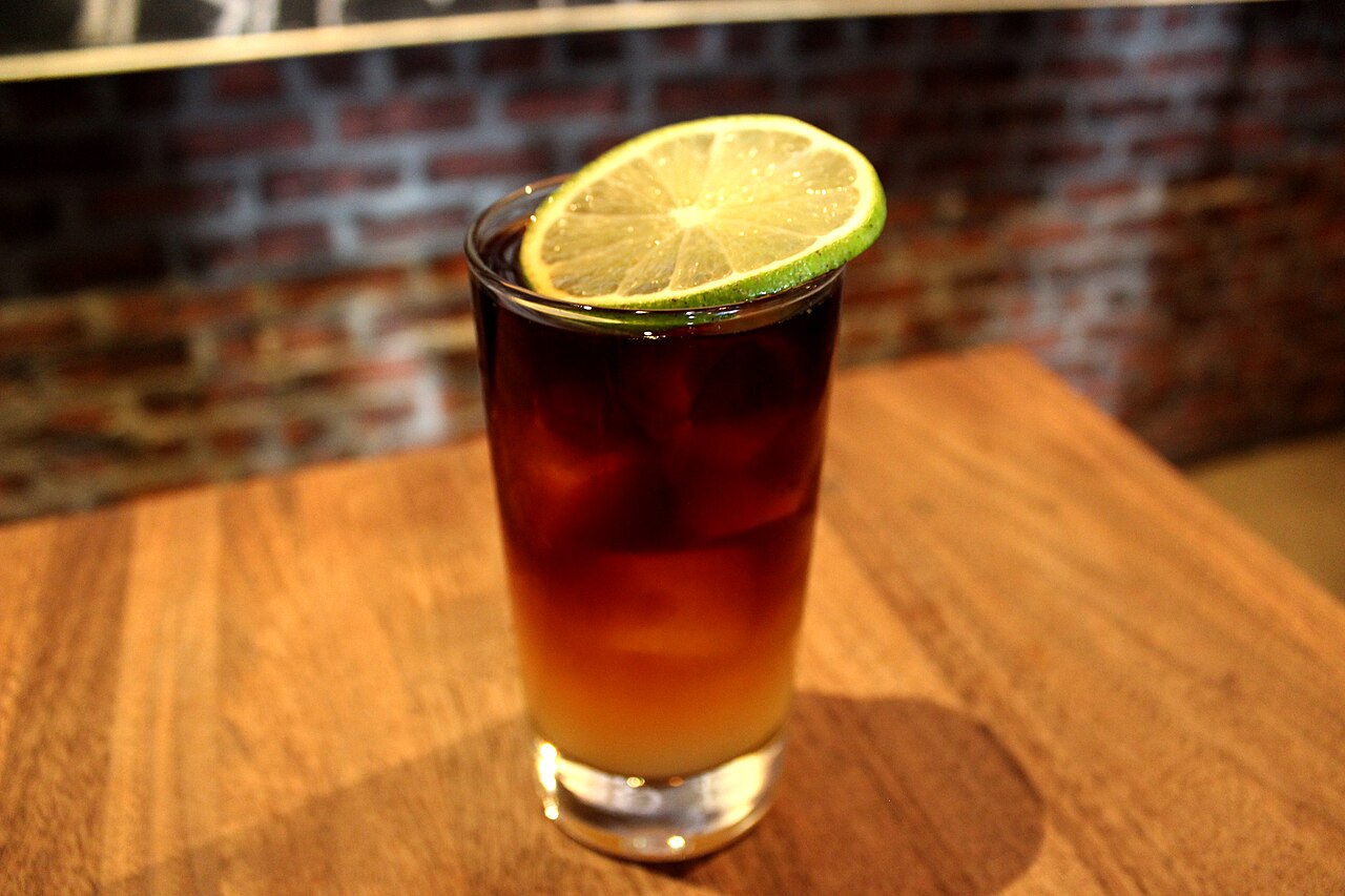 A dark red wine float over a citrus cocktail